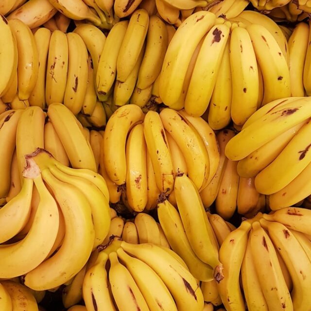 yellow banana fruit on brown wooden table