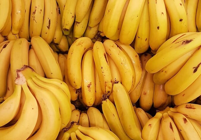 yellow banana fruit on brown wooden table